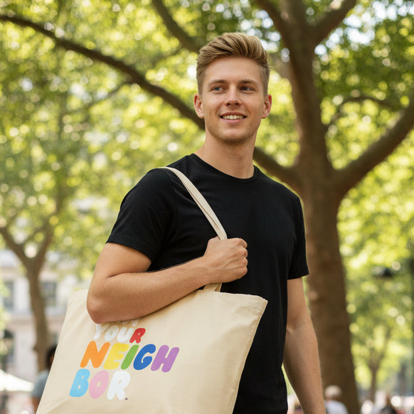 Man carrying the I Am Your Neighbor in Color Jumbo Tote Bag from the Pride in the APWT Gift Shop Collection