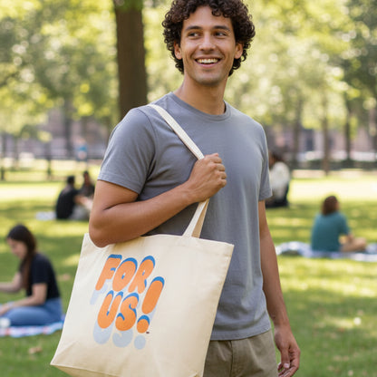 Man in a city park wearing the APWT Gift Shop's For Us in Blue and Orange Jumbo Tote Bag in Natural
