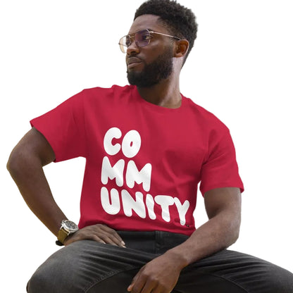 man wearing A Community in Apple Red Unisex T-Shirt from the APWT Gift Shop Sitting