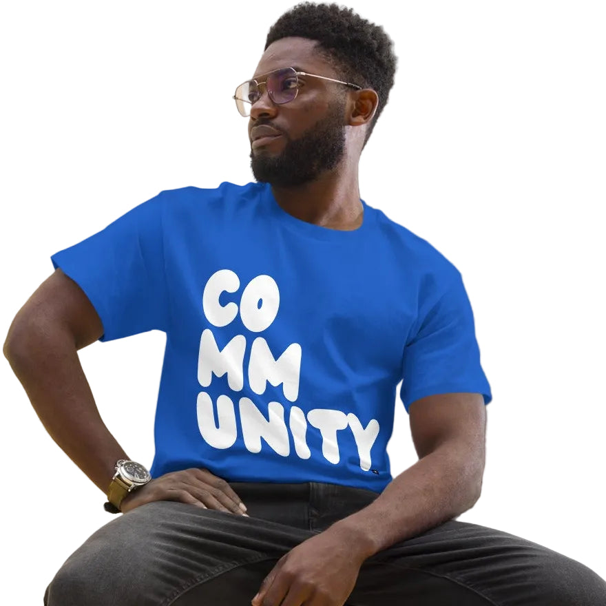 man wearing A Community in Ocean Blue Unisex T-Shirt from the APWT Gift Shop sitting