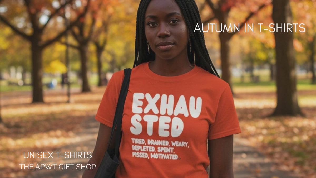 Load video: Woman walking through the park on an autumn day wearing the APWT Gift Shop's Exhausted in Orange Unisex T-Shirt from the Exhausted Collection