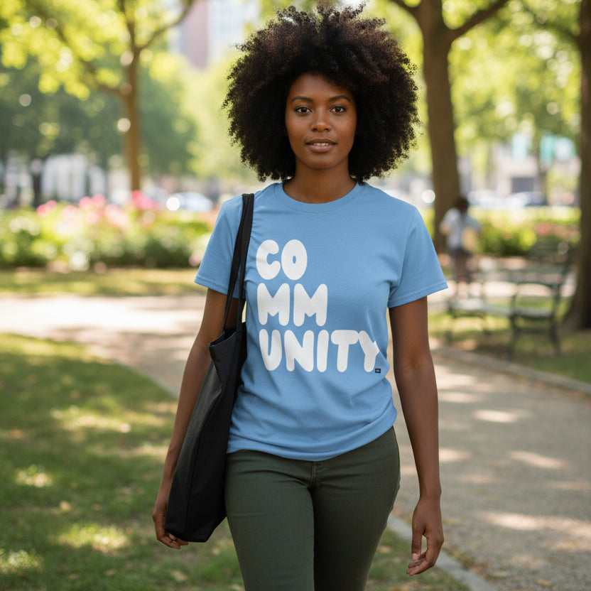 Woman walking through the park wearing the APWT Gift Shop's A Community in Sky Blue Unisex T-Shirt from the Community Collection