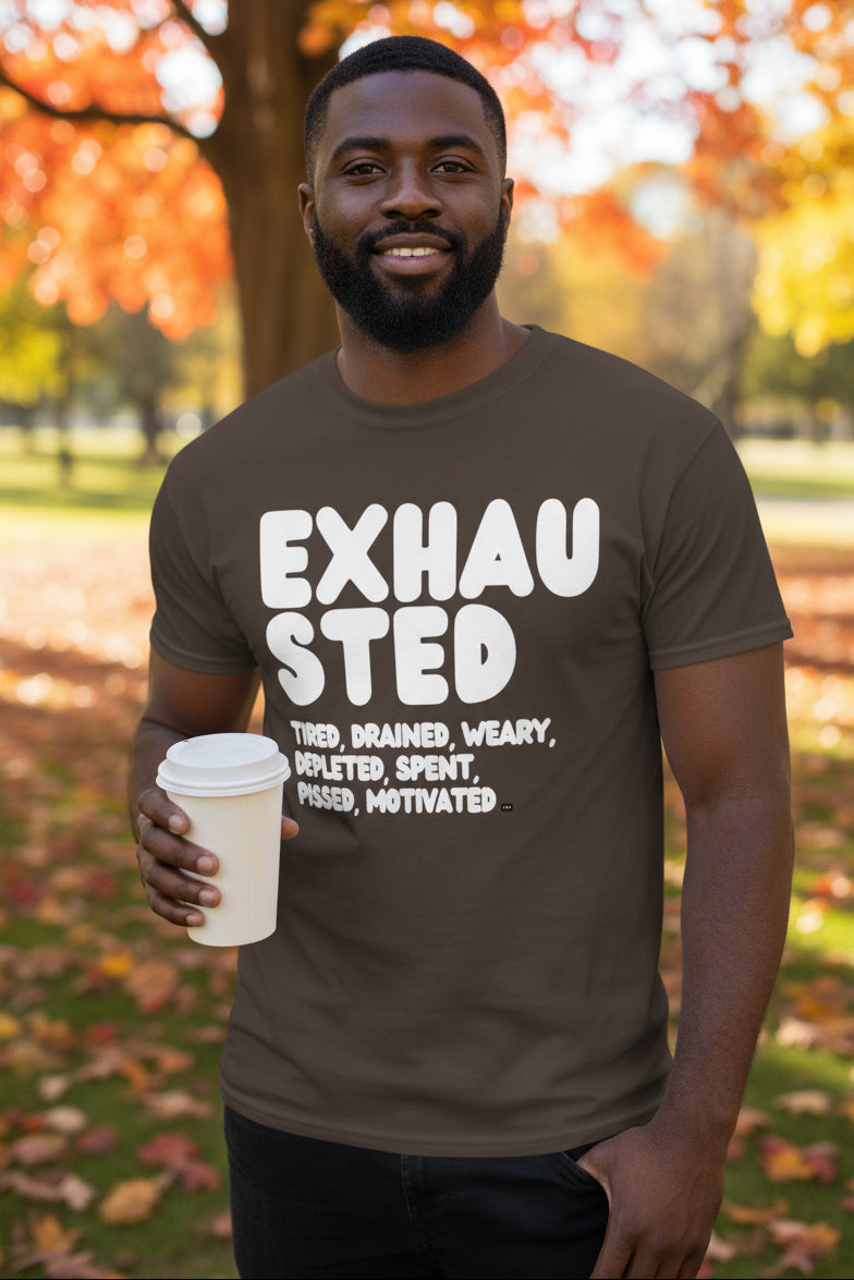 Man standing in the park on an autumn day wearing the APWT Gift Shop's Exhausted in Brown Unisex T-Shirt from the Exhausted Collection