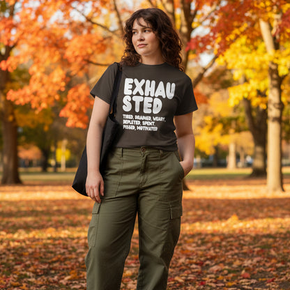 Woman standing in the park on an autumn day wearing the APWT Gift Shop's Exhausted in Brown Unisex T-Shirt from the Exhausted Collection