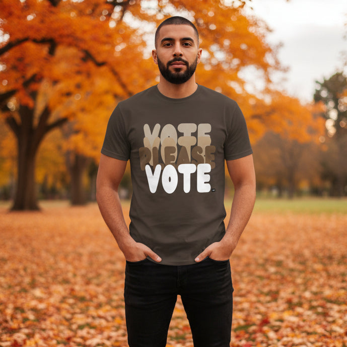 Man standing in the park on an autumn day wearing the APWT Gift Shop's Please Vote in Brown Love Unisex T-Shirt from the APWT Vote Shop