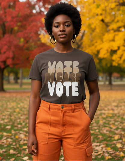 Woman standing in the park on an autumn day wearing the APWT Gift Shop's Please Vote in Brown Love Unisex T-Shirt from the APWT Vote Shop