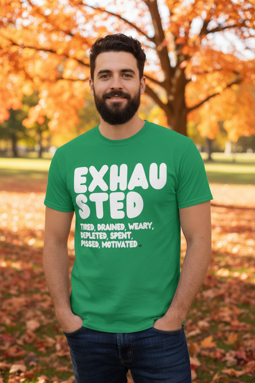 Man standing in the park on an autumn day wearing the APWT Gift Shop's Exhausted in Green Unisex T-Shirt from the Exhausted Collection