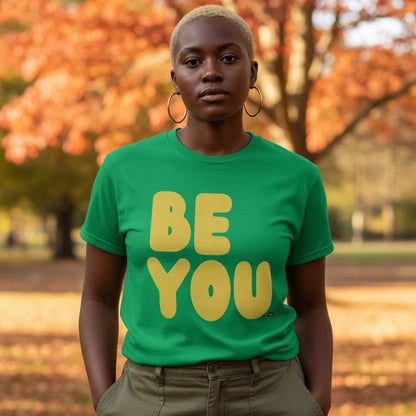Woman standing in the park on an autumn day wearing the APWT Gift Shop's Be You in Green and Yellow Unisex T-Shirt from the Be You Collection