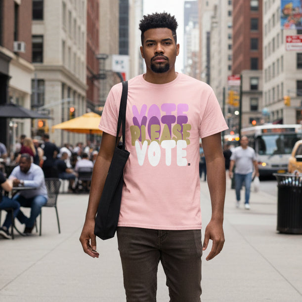 Man walking down a city street wearing the APWT Gift Shop's Please Vote in Primaries Pink Unisex T-Shirt from the APWT Vote Shop