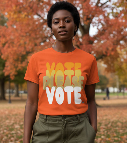 Woman standing in the park on an autumn day wearing the APWT Gift Shop's Please Vote in Safety Cone Orange Unisex T-Shirt from the APWT Vote Shop