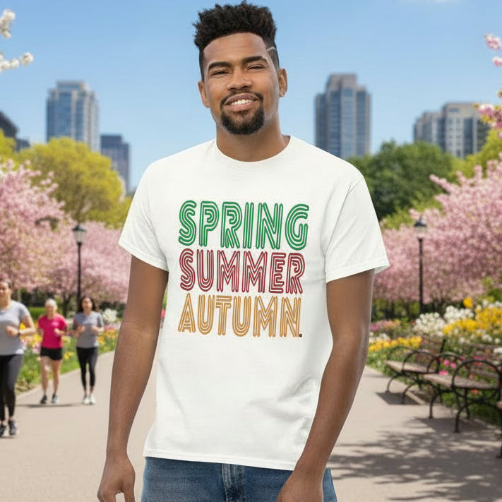 Man wearing a white t-shirt with 'Spring Summer Autumn' text in a park.