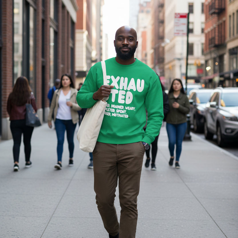 Man walking down a city street wearing the APWT Gift Shop's Exhausted in Green Unisex Crew Neck Sweatshirt from the Exhausted Collection