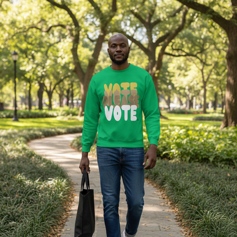 Man walking through a city park wearing the APWT Gift Shop's Please Vote in Green Spaces Unisex Crew Neck Sweatshirt from the APWT Vote Shop