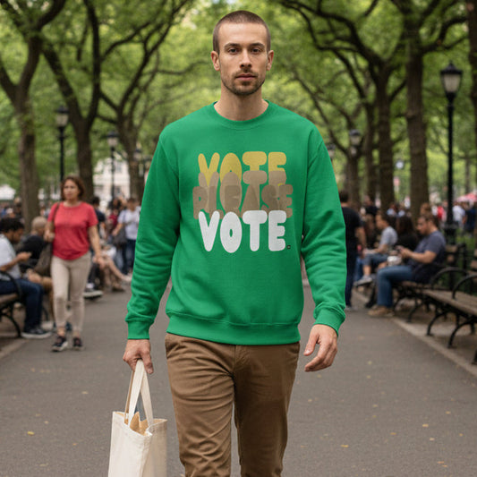 Man walking through a city park wearing the APWT Gift Shop's Please Vote in Green Spaces Unisex Crew Neck Sweatshirt from the APWT Vote Shop