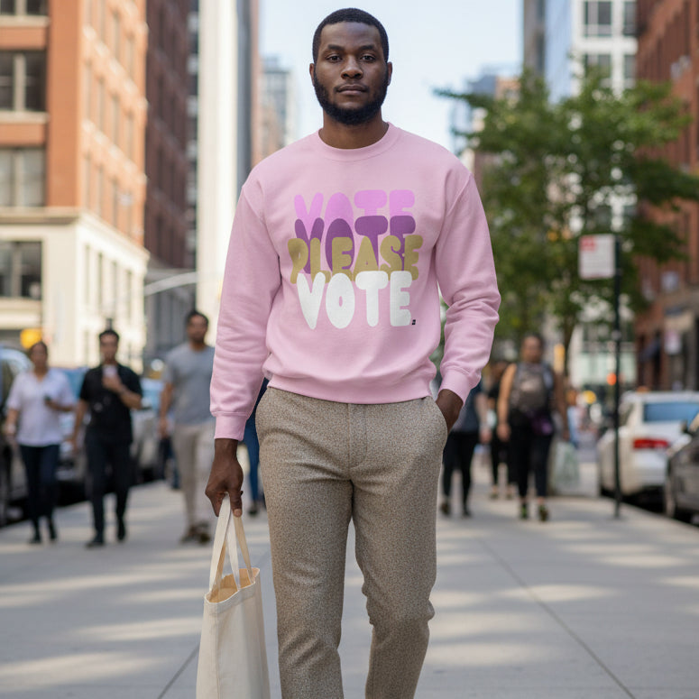 Man walking down a city street wearing the APWT Gift Shop's Please Vote in Primaries Pink Unisex Crew Neck Sweatshirt from the APWT Vote Shop
