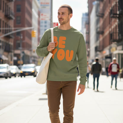 Man walking down the street wearing The APWT Gift Shop's Be You in Olive Green and Orange Unisex Crew Neck Sweatshirt from the Be You Collection 