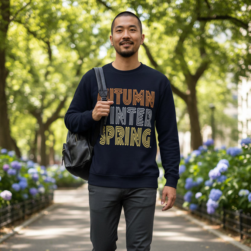 Man walking through the park wearing the APWT Gift Shop's Fall in Autumn Unisex Crew Neck Sweatshirt from the Day in the Life Collection in Navy Blue