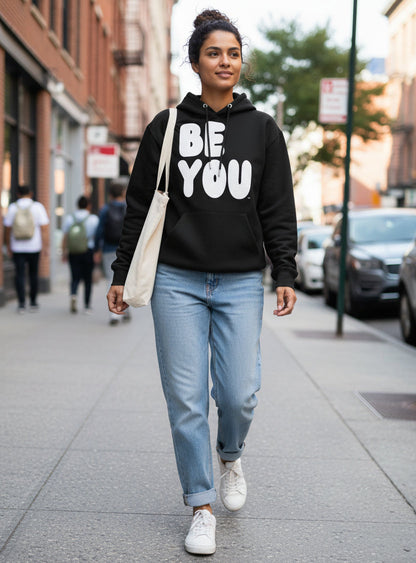 Woman walking down a city street wearing the APWT Gift Shop's Be You in Black and White Premium Unisex Hoodie from the Be You Collection and the Premium Basics Collection