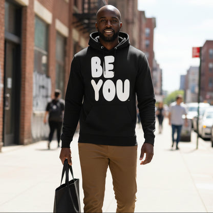 Man walking down a city street wearing the APWT Gift Shop's Be You in Black and White Premium Unisex Hoodie from the Be You Collection and the Premium Basics Collection