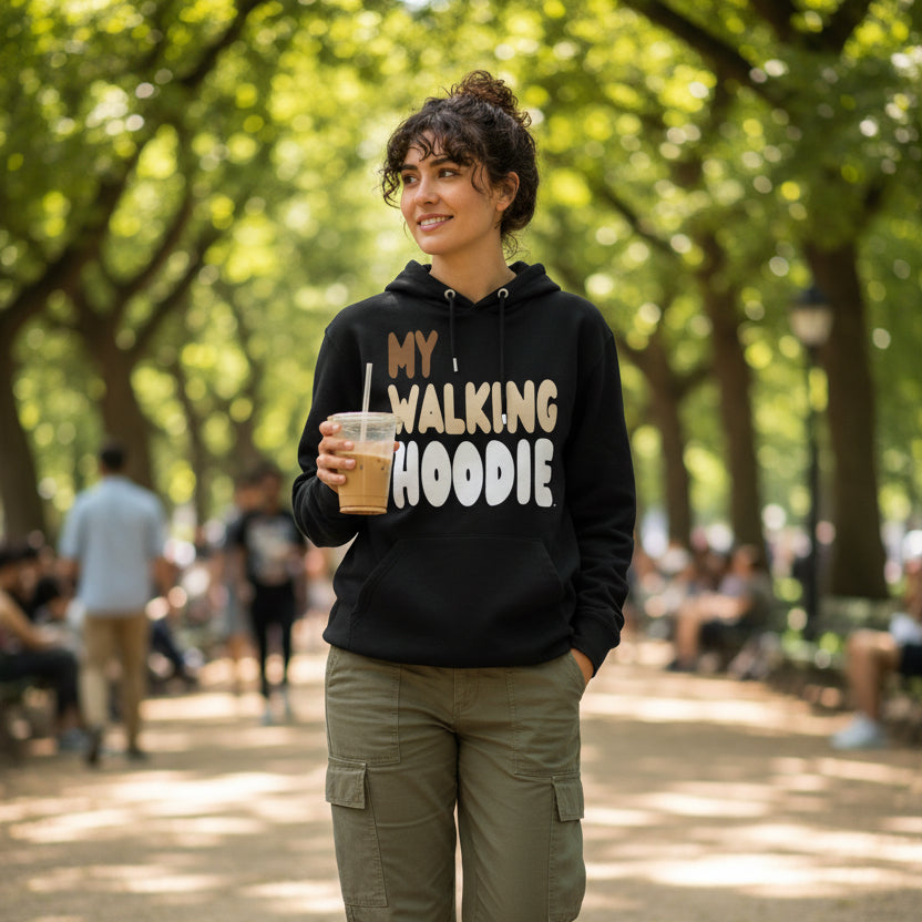 Woman walking down a city street wearing the APWT Gift Shop's My Walking Hoodie Premium Unisex Hoodie from the Day in the Life Collection in Black