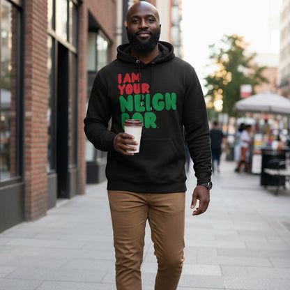 Man walking down a city street wearing the APWT Gift Shop's I Am Your Neighbor in Black Premium Unisex Hoodie from the Black Collection and the  Premium Basics Collection