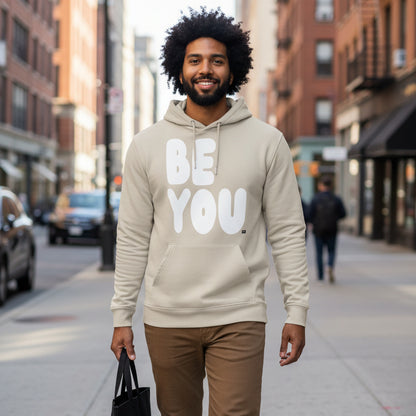 Man walking down a city street wearing the APWT Gift Shop's Be You in Beige and White Premium Unisex Hoodie from the Be You Collection and the Premium Basics Collection