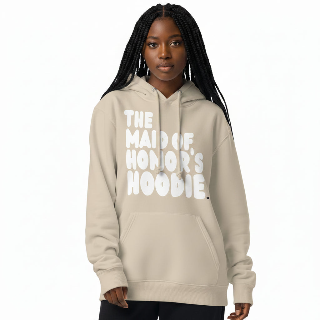 Woman wearing the APWT Gift Shop's Maid of Honor's Hoodie Premium Unisex Hoodie from the APWT Wedding Shop in Beige