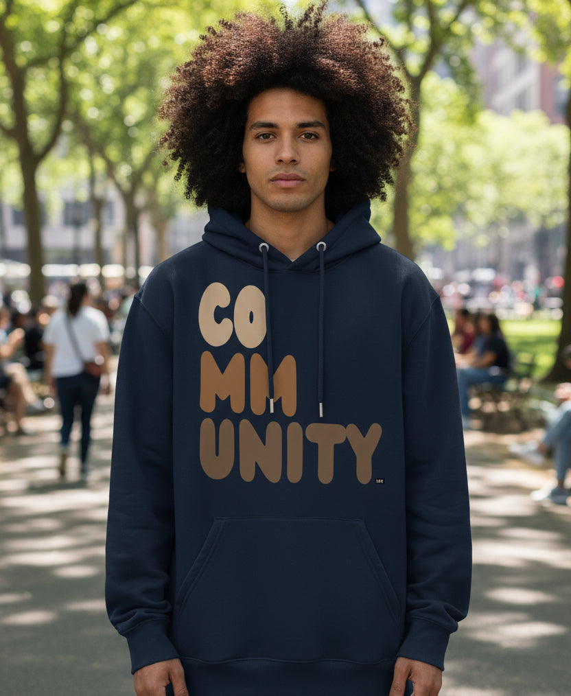 Man standing in a city park wearing the APWT Gift Shop's Our Community Premium Unisex Hoodie in Navy Blue from the Premium Basics Collection