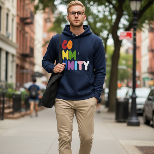 Man walking down a city sidewalk wearing the APWT Gift Shop's Rainbow Community Premium Unisex Hoodie from the Community Collection and the Pride in the APWT Gift Shop Collection