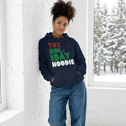 Woman standing in a white room wearing The Holiday Hoodie Premium Unisex Hoodie from the APWT Holiday Shop and the Day in the Life Collection in Navy Blue