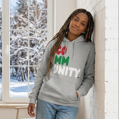 Woman standing in a white room wearing The APWT Gift Shop's Holiday Community Premium Unisex Hoodie from the Community Collection and the APWT Holiday Shop