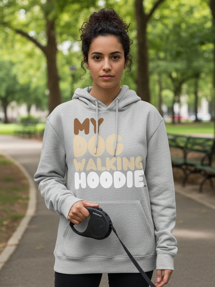 Woman standing in a city park wearing the APWT Gift Shop's My Dog Walking Hoodie Premium Unisex Hoodie from the Day in the Life Collection in Grey