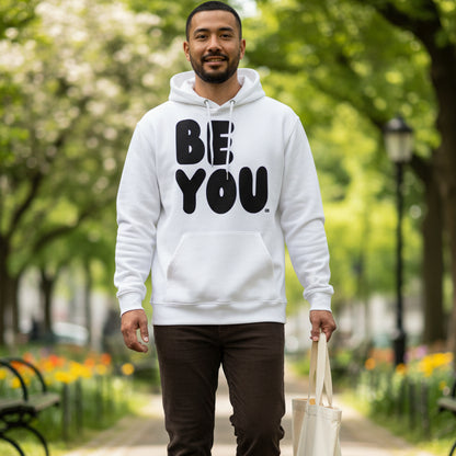 man walking through a city park  wearing the APWT Gift Shop's Be You in Black and White Premium Unisex White Hoodie from the Be You Collection