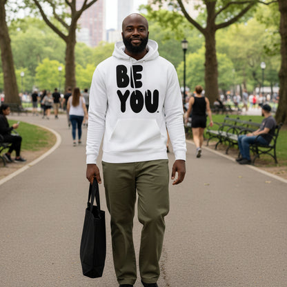 man walking through a city park  wearing the APWT Gift Shop's Be You in Black and White Premium Unisex White Hoodie from the Be You Collection