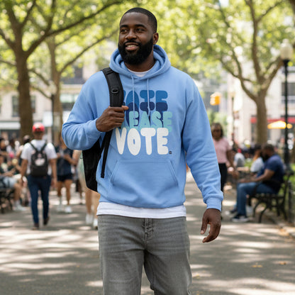 Man walking through a city park wearing the APWT Gift Shop's Please Vote in Sky Blue Unisex Hoodie from the APWT Vote Shop