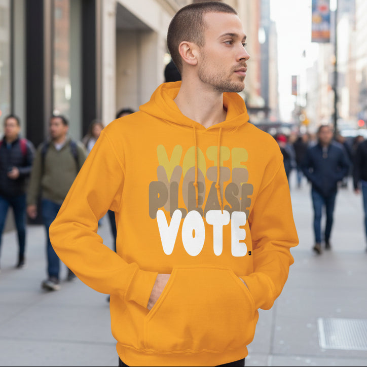 Man walking down a city street wearing the APWT Gift Shop's Please Vote in Sunny Yellow Unisex Hoodie from the APWT Vote Shop