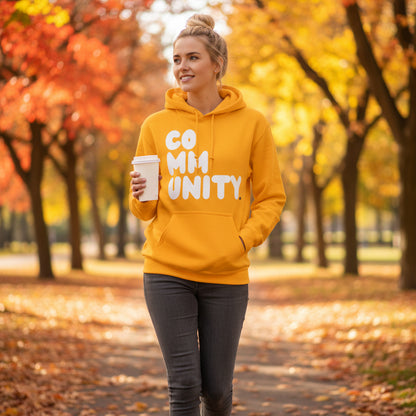 Woman walking through a city park wearing the APWT Gift Shop's A Community in Sunny Yellow Unisex Hoodie from the Community Collection