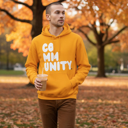 Man walking through a city park wearing the APWT Gift Shop's A Community in Sunny Yellow Unisex Hoodie from the Community Collection