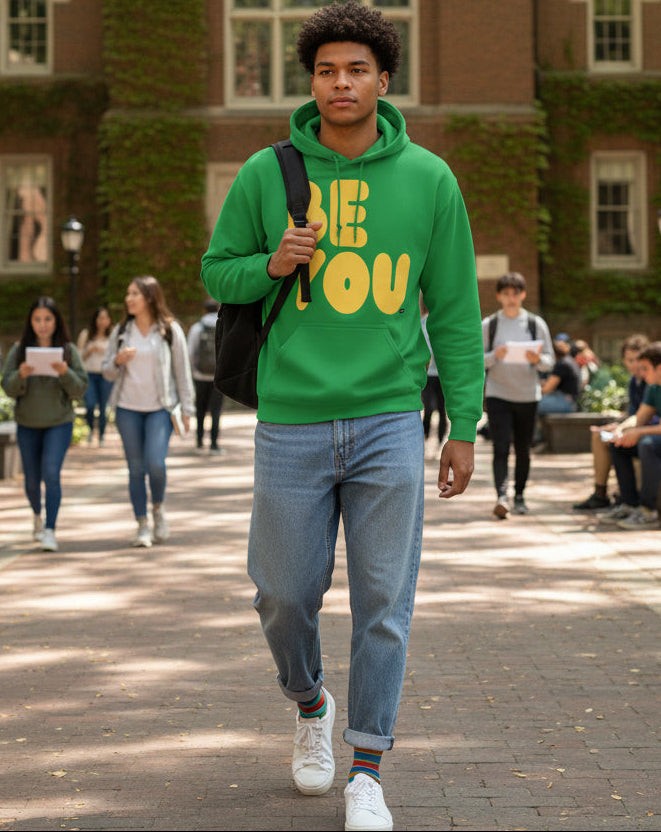 Man walking on a college campus wearing the APWT Gift Shop's Be You in Green and Yellow Unisex Hoodie from the Be You Collection