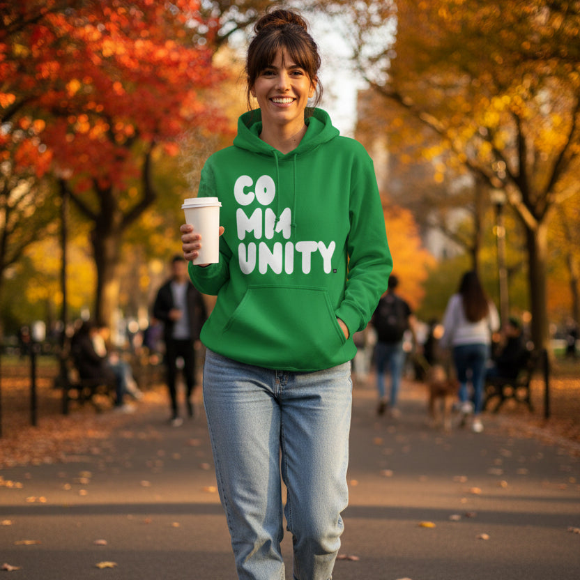Woman walking through the park wearing the APWT Gift Shop's A Community in Green Grass Unisex Hoodie from the Community Collection