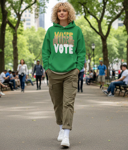Woman walking through a city park wearing the APWT Gift Shop's Please Vote in Green Spaces Unisex Hoodie from the APWT Vote Shop