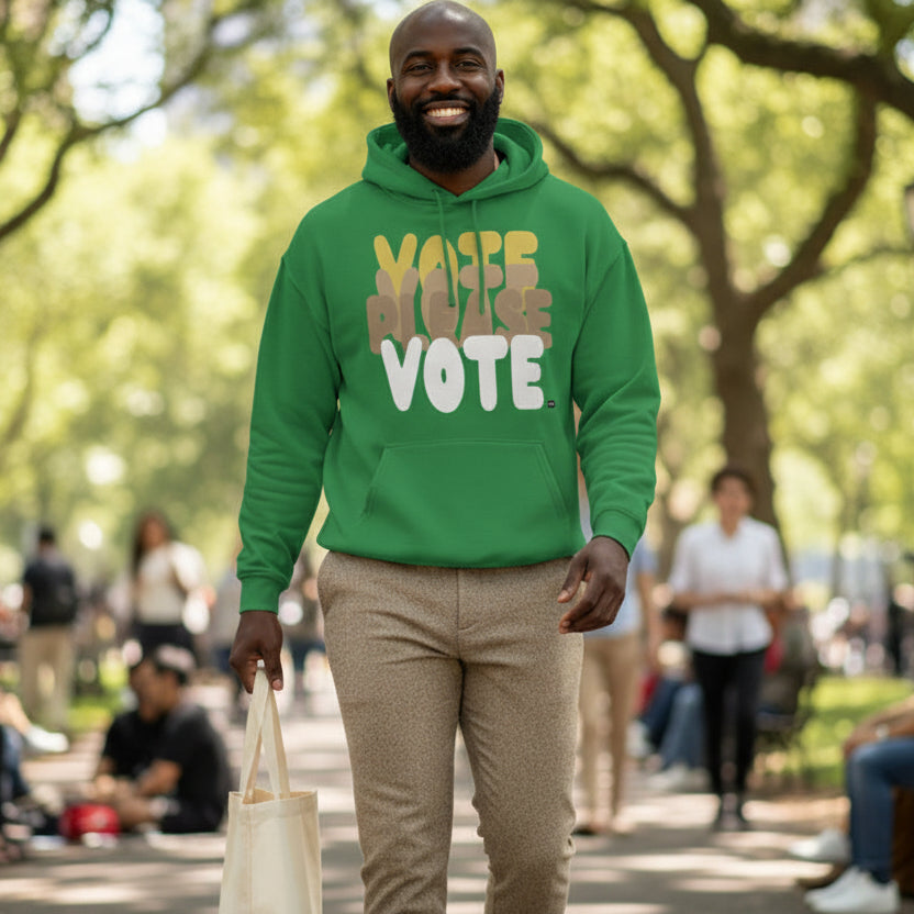 Man walking through a city park wearing the APWT Gift Shop's Please Vote in Green Spaces Unisex Hoodie from the APWT Vote Shop