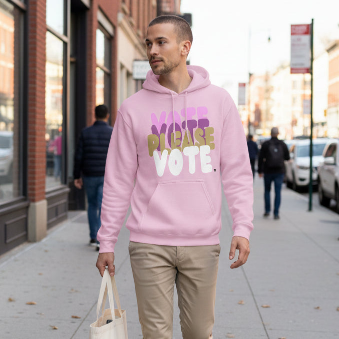 Man walking down a city street wearing the APWT Gift Shop's Please Vote in Primaries Pink Unisex Hoodie from the APWT Vote Shop