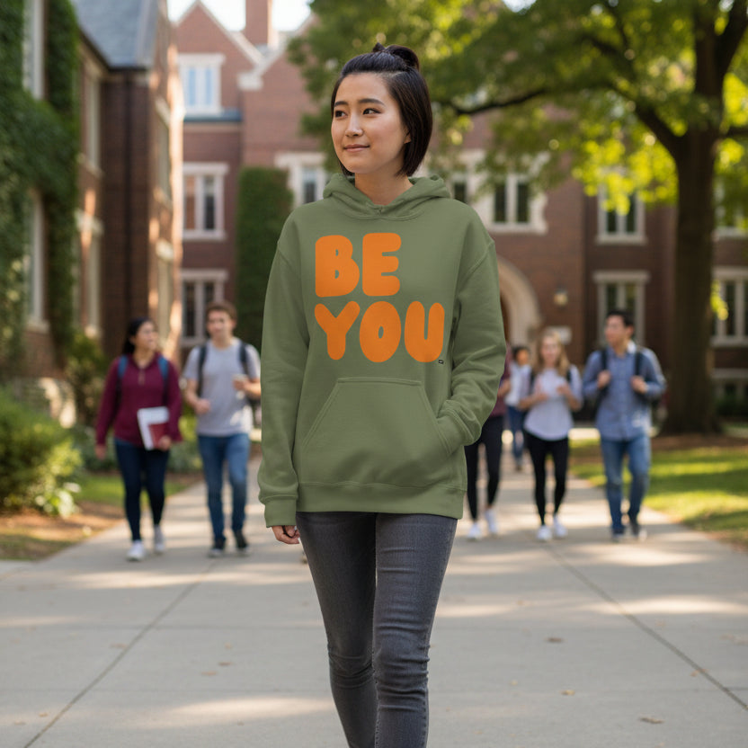 Woman walking on a college campus wearing the APWT Gift Shop's Be You in Olive Green and Orange Unisex Hoodie from the Be You Collection