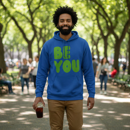 man walking through a city park wearing the APWT Gift Shops Be You in Blue and Green Unisex Hoodie from the Be You Collection