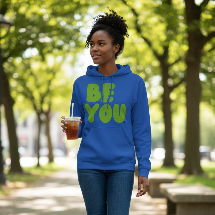 Woman walking through a city park wearing the APWT Gift Shops Be You in Blue and Green Unisex Hoodie from the Be You Collection