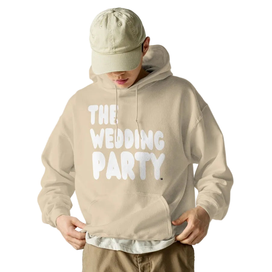 Man wearing the APWT Gift Shop's The Wedding Party Unisex Hoodie from the APWT Wedding Shop in beige