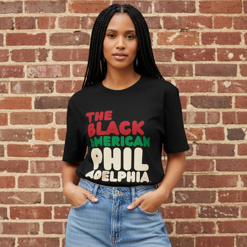 Woman wearing the APWT Gift Shop's the Black American Philadelphia Premium Unisex T-Shirt from the Black Collection