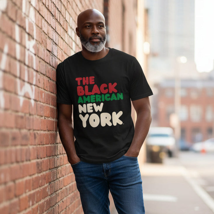 Man wearing the APWT Gift Shop's the Black American New York Premium Unisex T-Shirt from the Black Collection