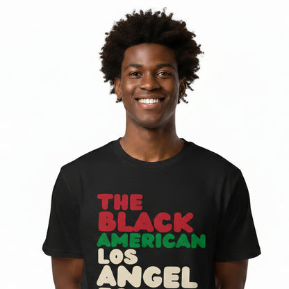 Man wearing the APWT Gift Shop's The Black American Los Angeles Premium Unisex T-Shirt from the Black Collection